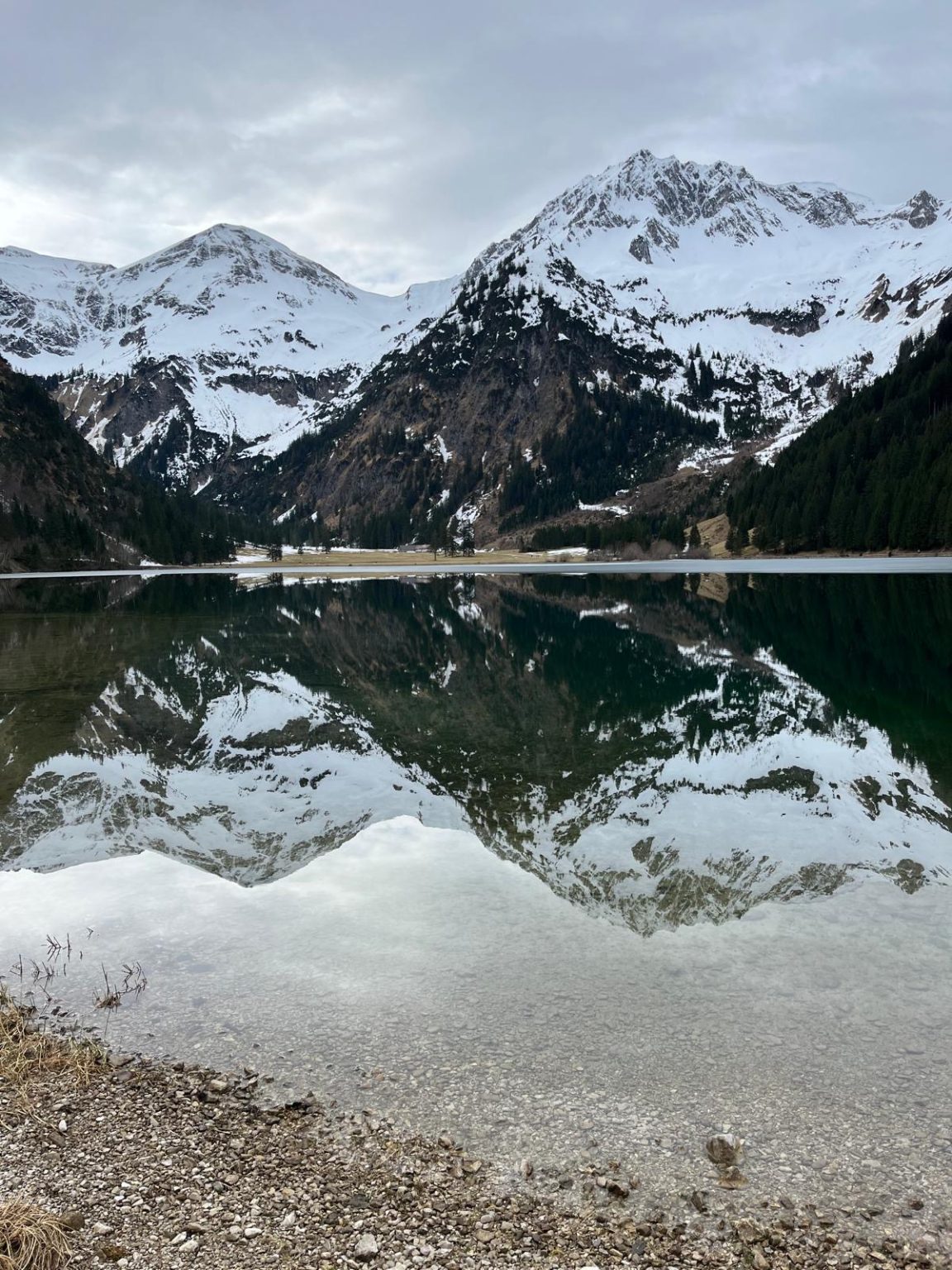 Spiegelung der verschneiten Berge im See